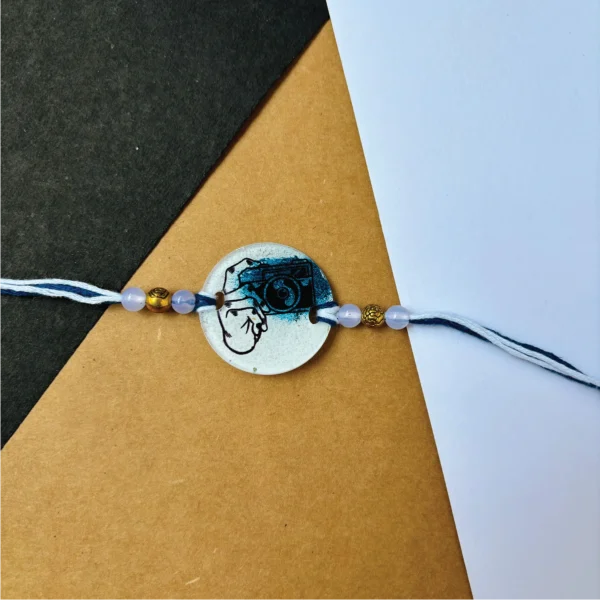 115-1-no-gift-camera-themed-paintedrakhi-1.webp Camera Themed Painted Rakhi - Personalised Rakhi for Brother by Bubbly Decors
